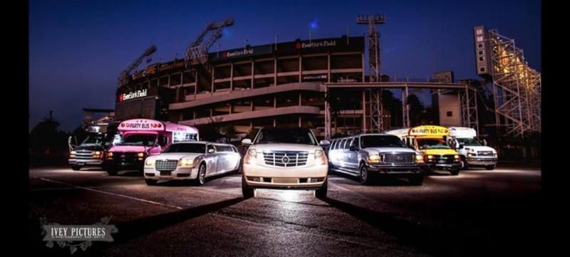 Line of cars racing toward camera at a stadium track at dusk, with a partially built structure behind them