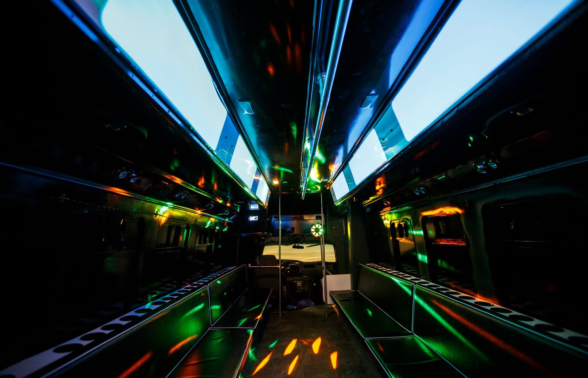 Futuristic neon-lit corridor inside a bus or train, with blue and green lights reflecting on glossy surfaces