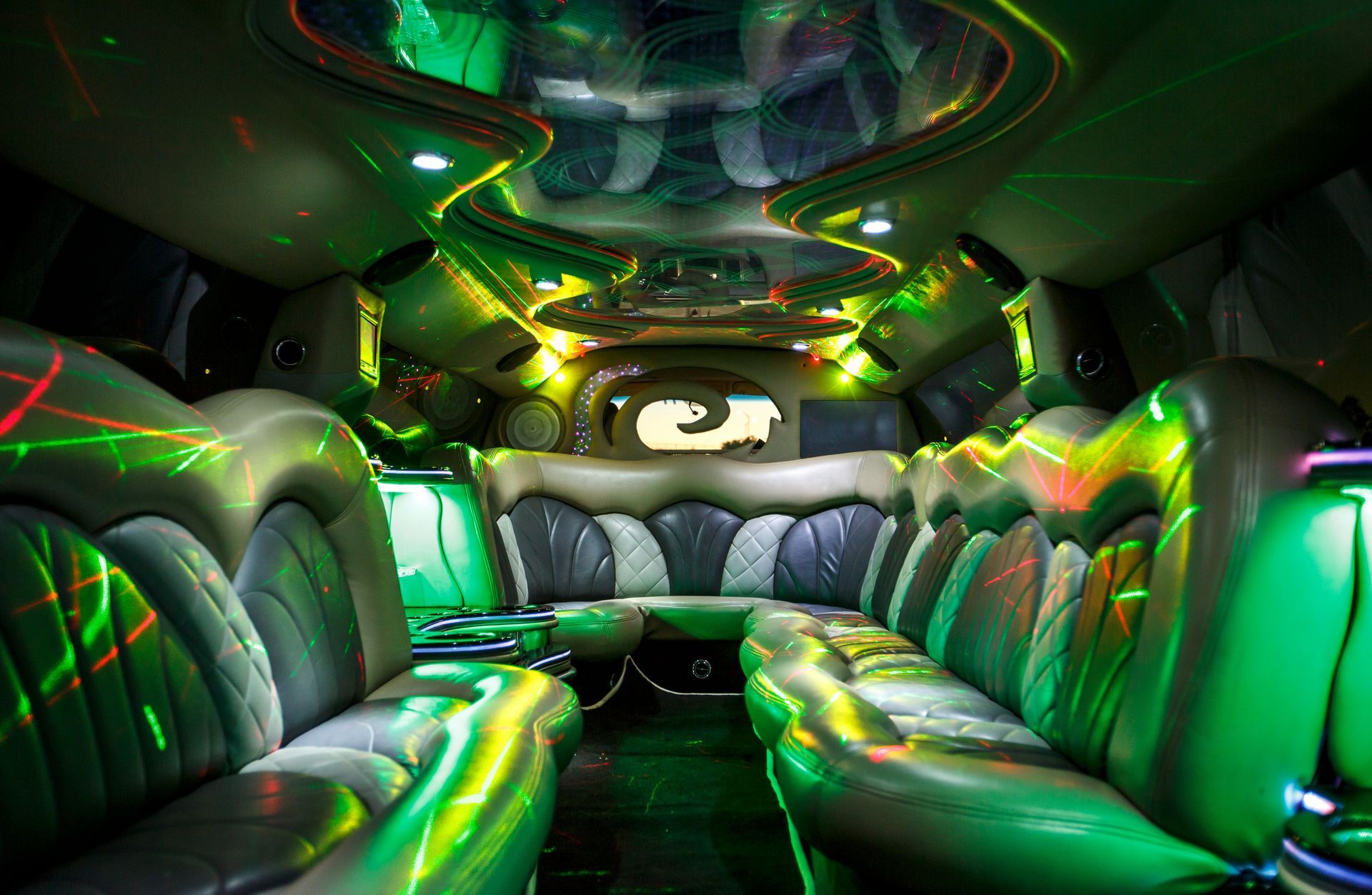 Futuristic black-and-neon-green limousine interior with leather seats and glowing LED lights