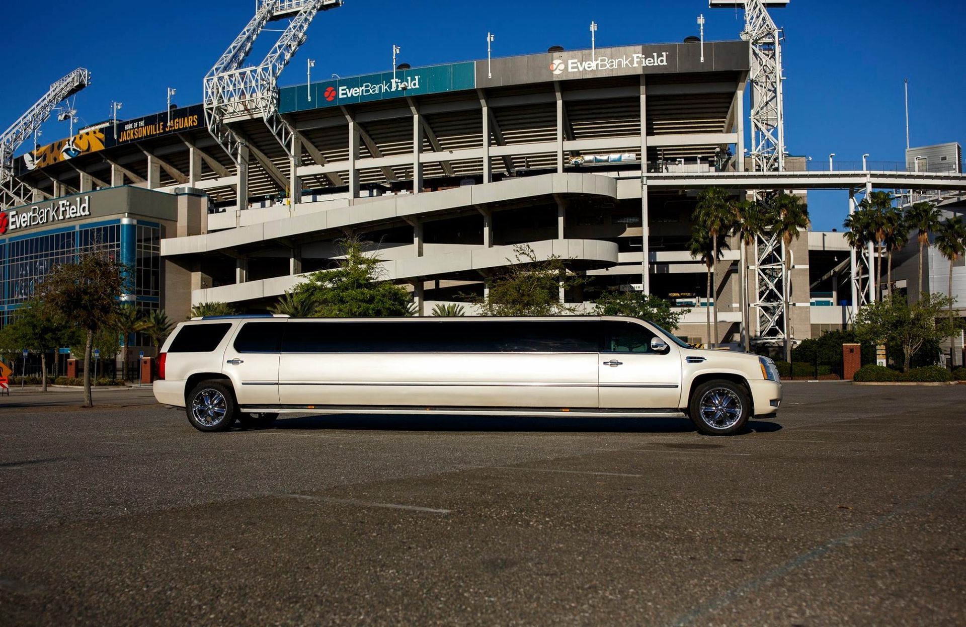 White stretch limousine parked in front of a stadium under construction