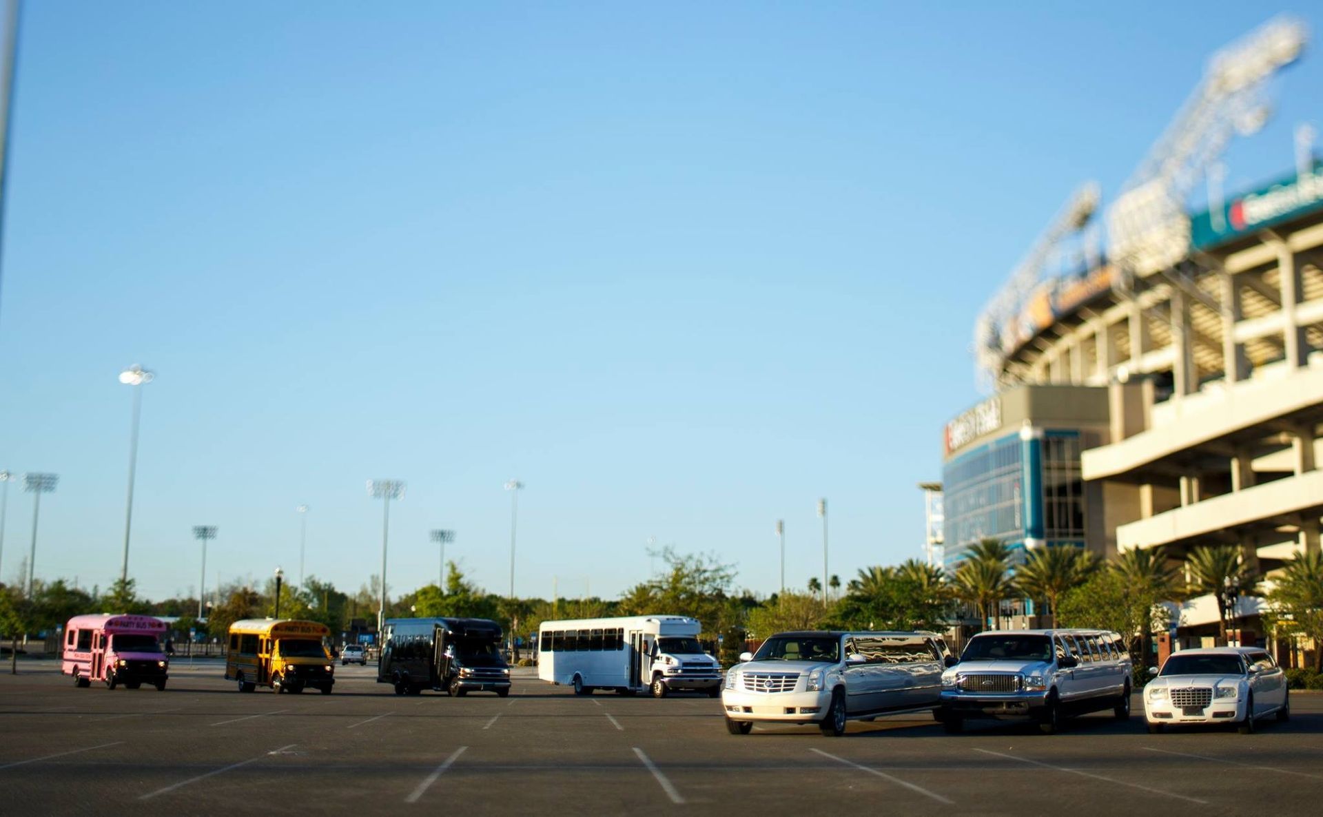 Parking lot outside a stadium with cars and a clear blue sky