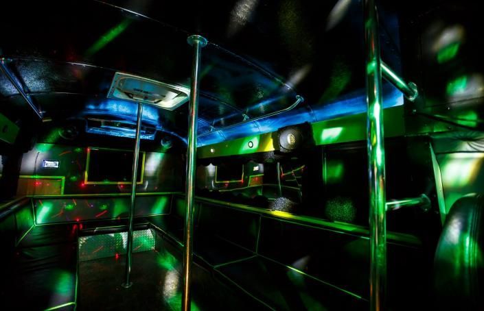 Empty subway car with shiny metal poles and neon green-blue lighting