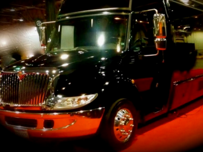 Black and red semi-truck parked indoors, viewed from the front-left side
