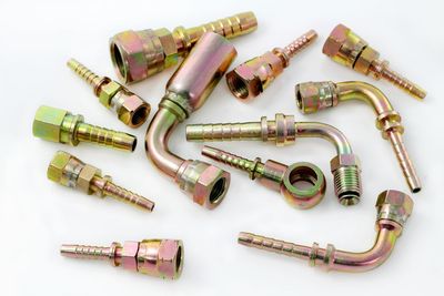 A bunch of different types of hose fittings on a white surface