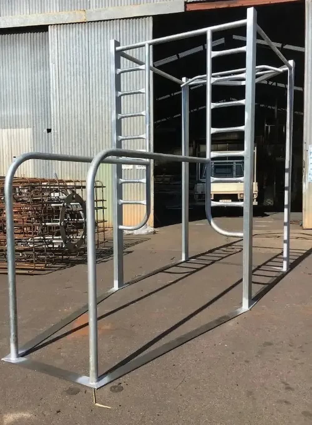 Metal Playground Structure With Ladders and Bars Stands on Concrete