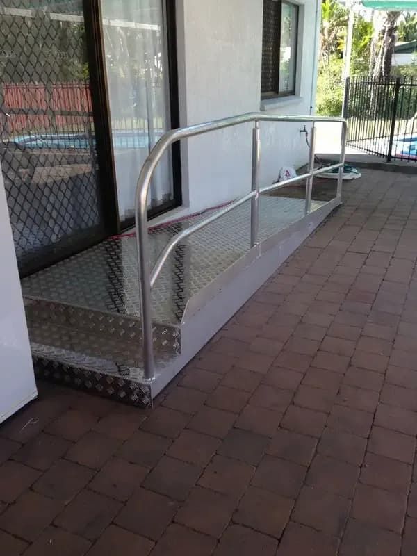 Metal Wheelchair Ramp With Handrails on a Brick Patio