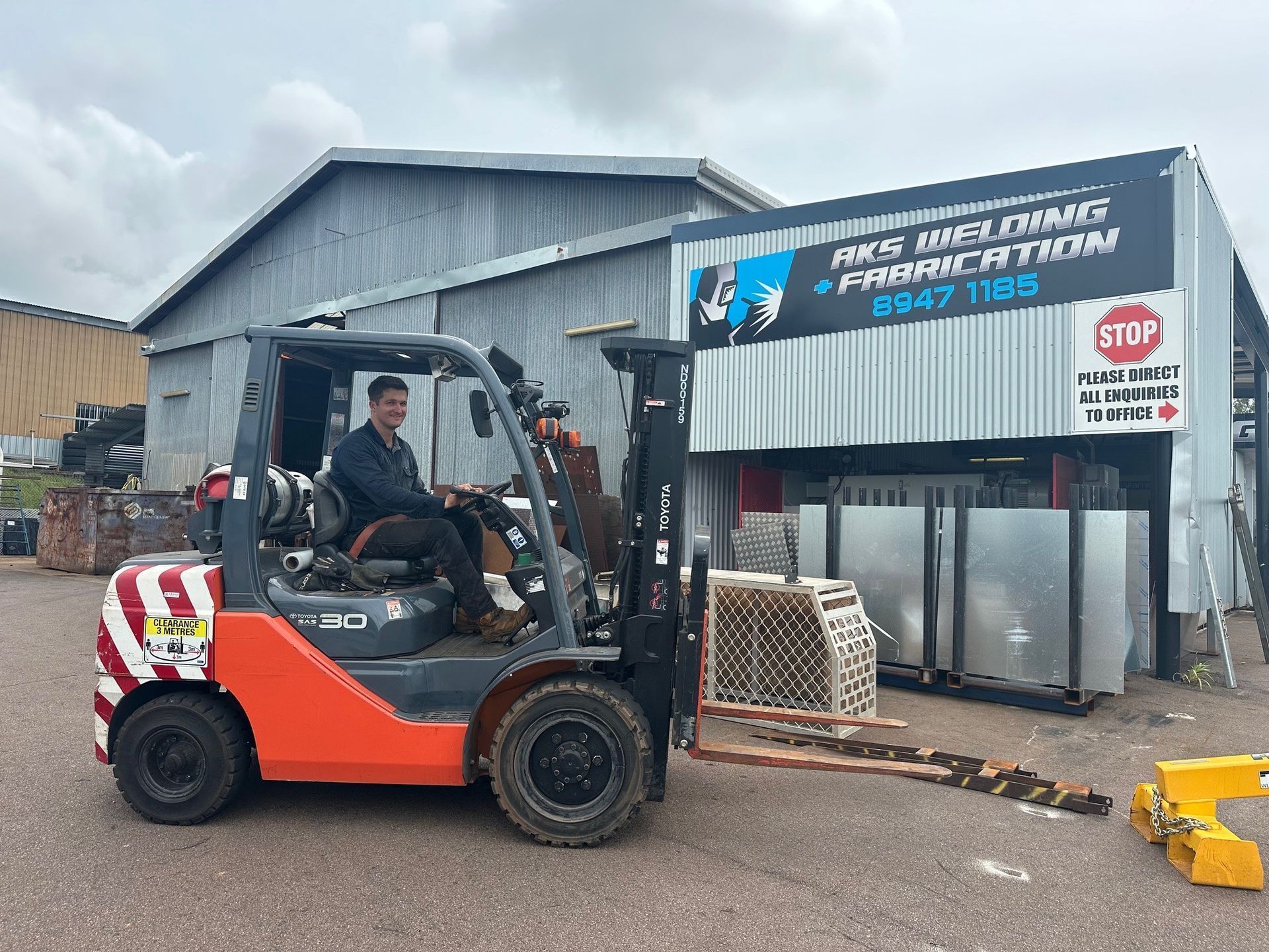 A Man in a Vehicle in front of Commercial Building — AKS Welding & Fabrication in Winnellie, NT