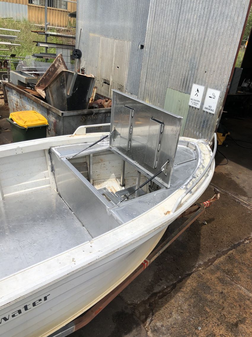 A Boat is Sitting on the Ground in Front of a Building — AKS Welding & Fabrication in Winnellie, NT