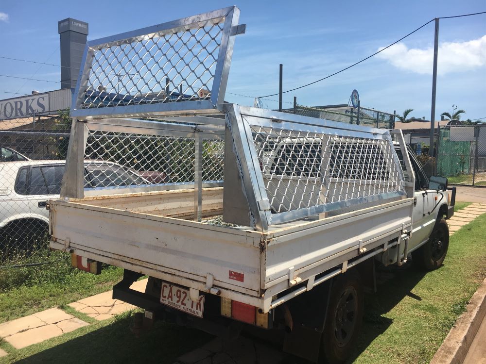 A Truck is Parked Under a Metal Structure in the Middle of a Dirt Road — AKS Welding & Fabrication in Winnellie, NT