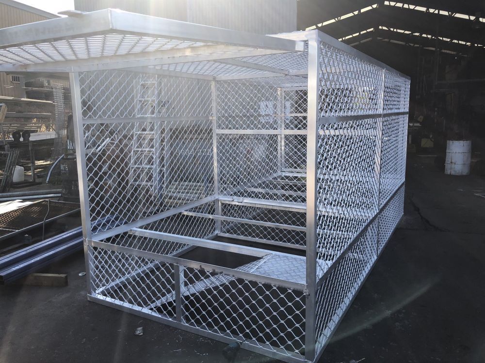 A metal cage is sitting on the ground in a warehouse.