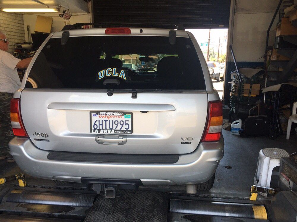 Silver SUV parked inside a garage, viewed from the rear with a visible license plate.
