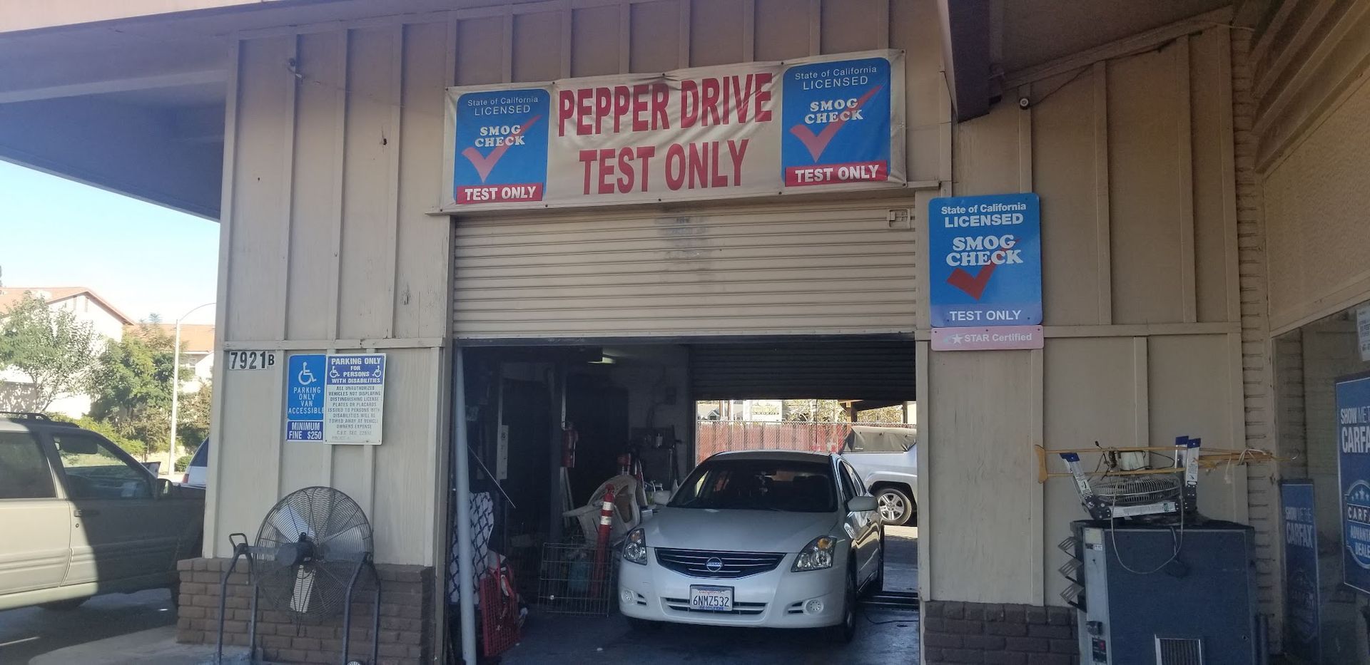 Car wash bay with sign reading “Pepper Drive Test Only” and a car inside the station
