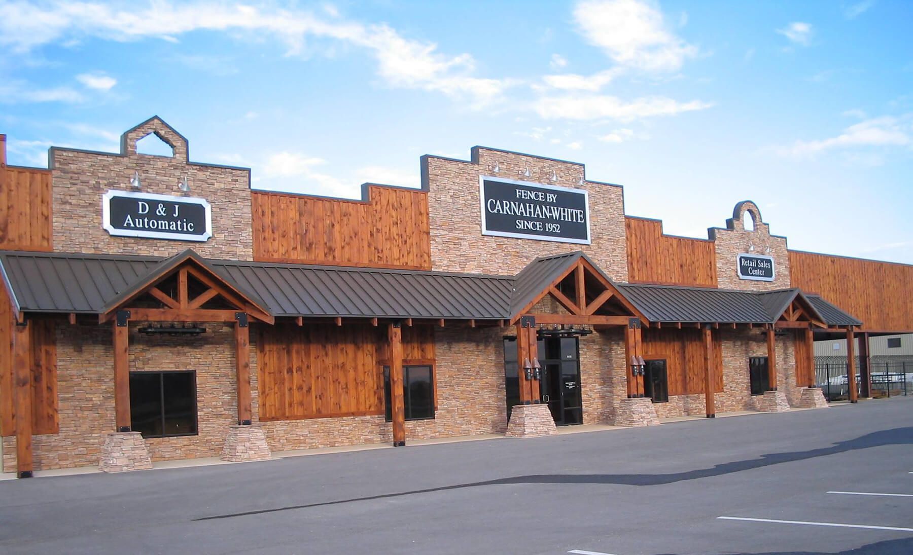 A large brick building with a metal roof and wooden trim | Fencing company in Springfield MO