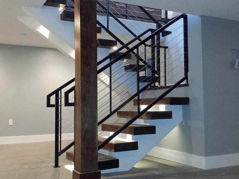 A staircase with a metal railing and wooden steps
