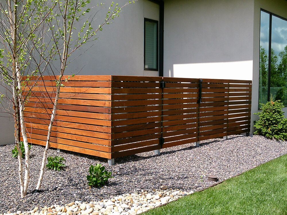 A wooden fence is sitting in front of a house.