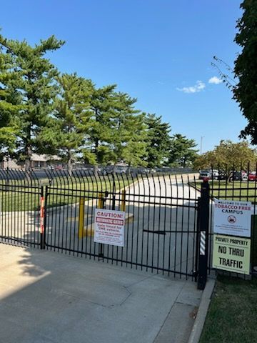 A fence with a sign that says caution on it | Black fencing springfield mo