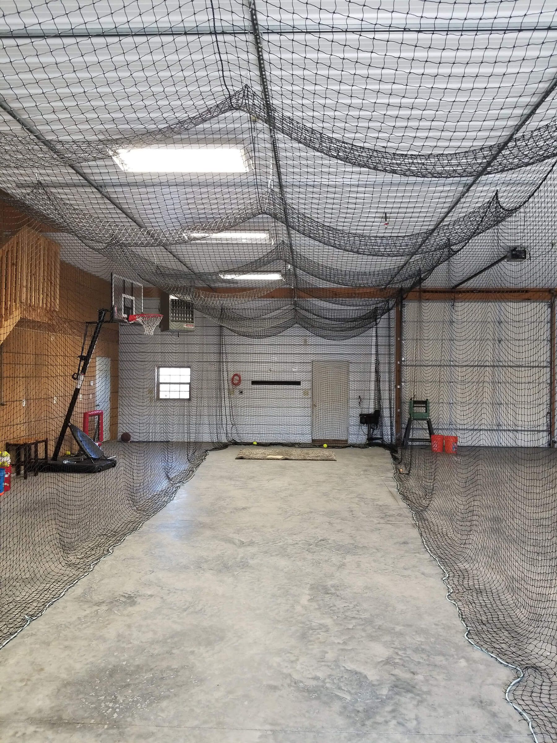 There is a basketball hoop in the ceiling of the garage.