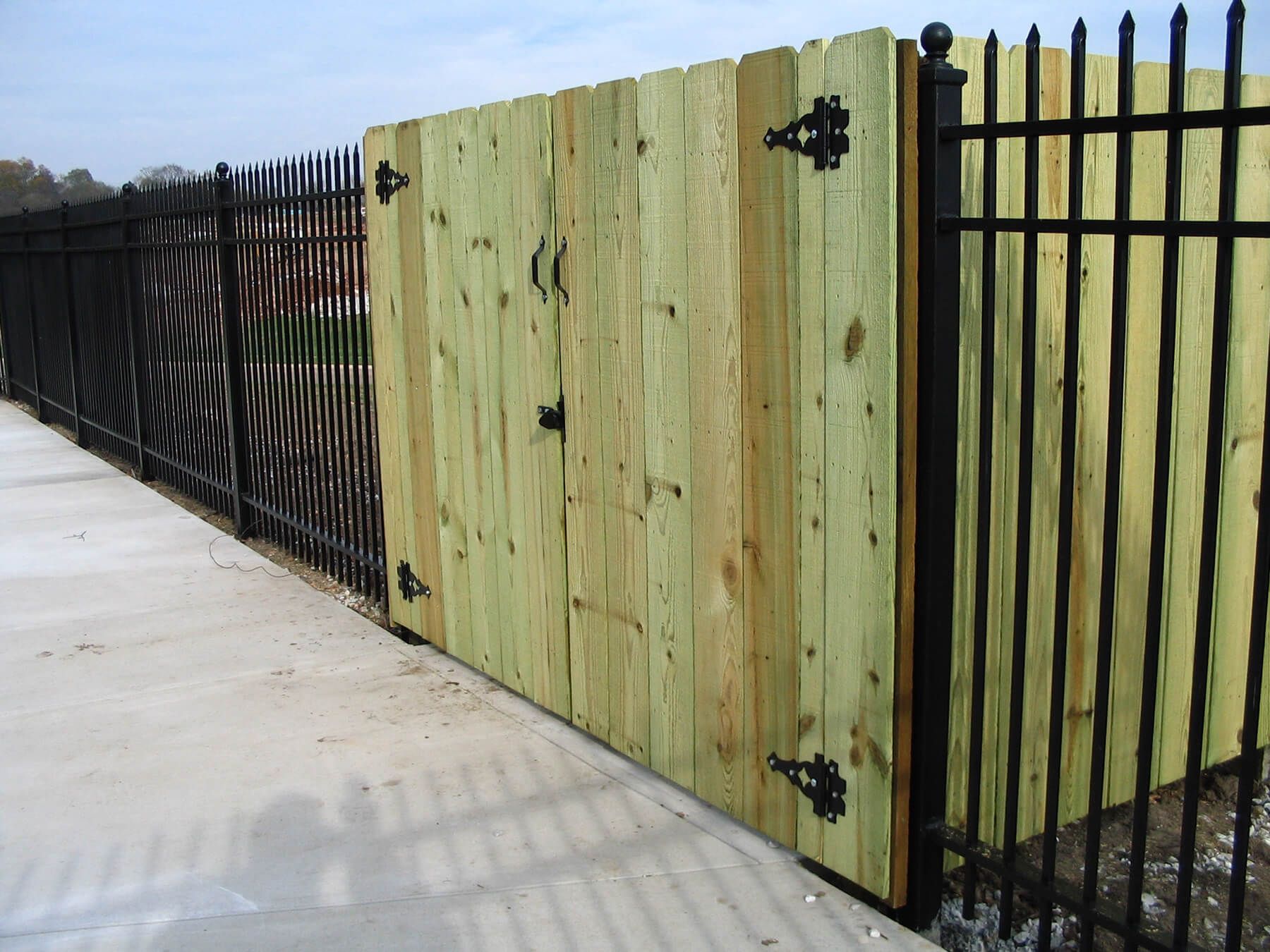 A white vinyl fence surrounds a lush green yard.