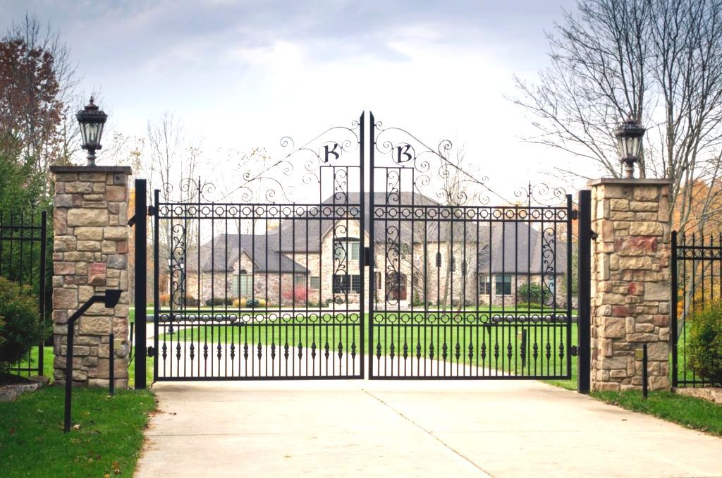 Supporter of Miami Tribe of Oklahoma A wrought iron gate is open to a driveway leading to a house | installation by fencing company in Springfield, Ozark, MO