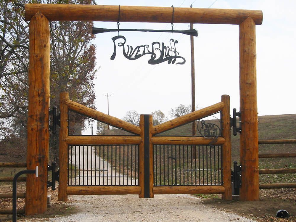 A wooden gate with a sign above it that says ranch