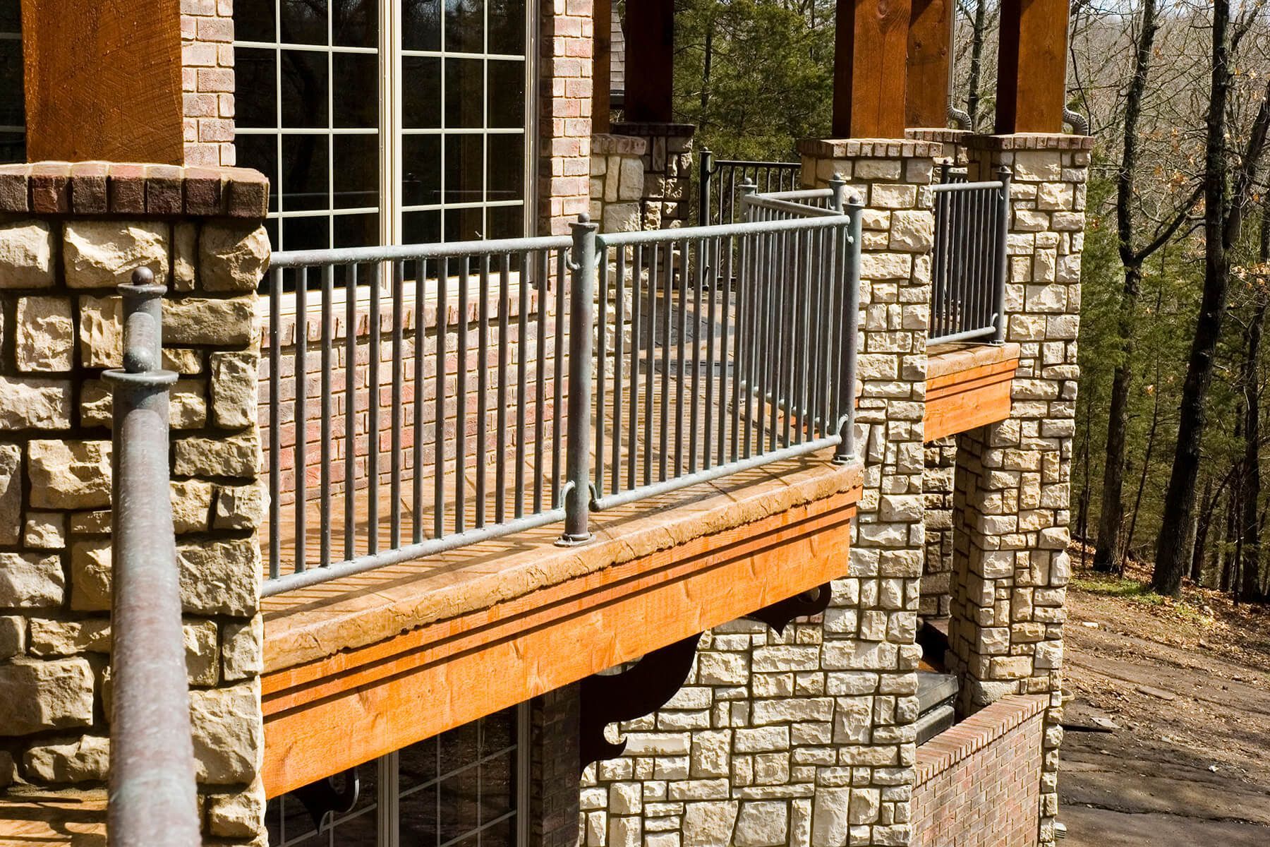 A stone building with a balcony and a metal railing