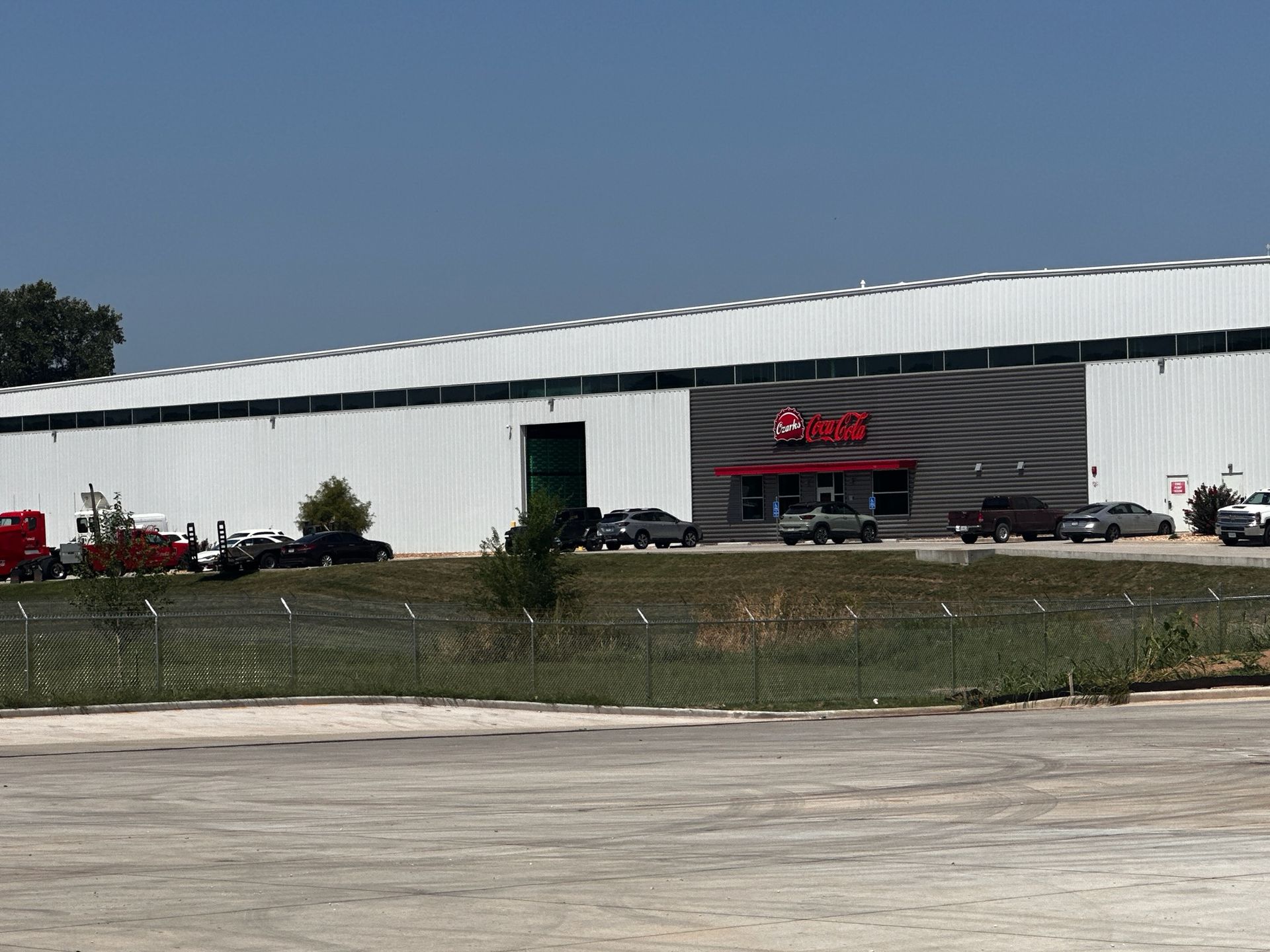 A large white building with a red sign on it | Commercial fencing springfield