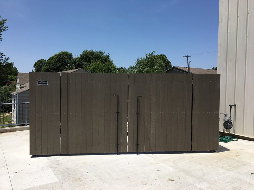 A large wooden fence is sitting in front of a building.