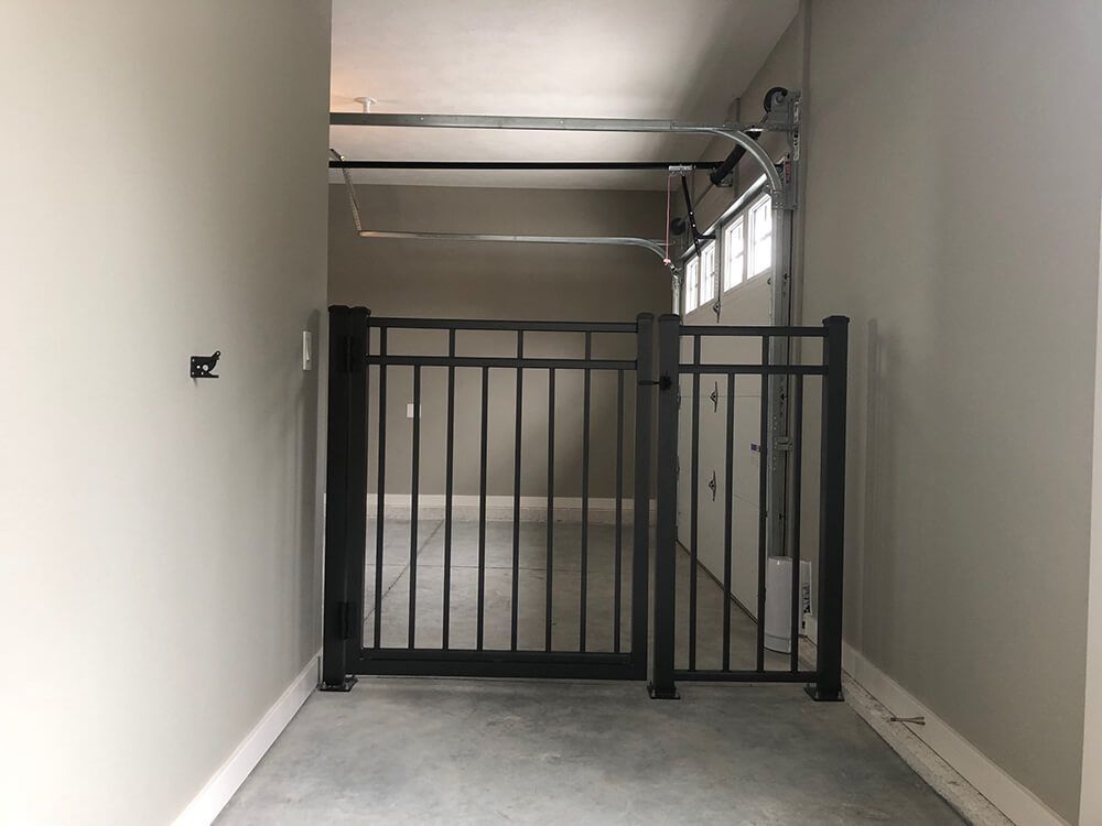 A garage with a black gate and a garage door open