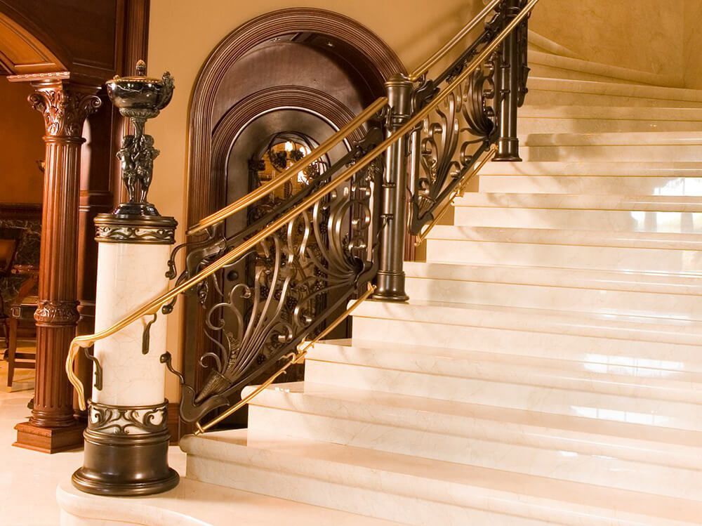 A staircase with a wrought iron railing and marble steps