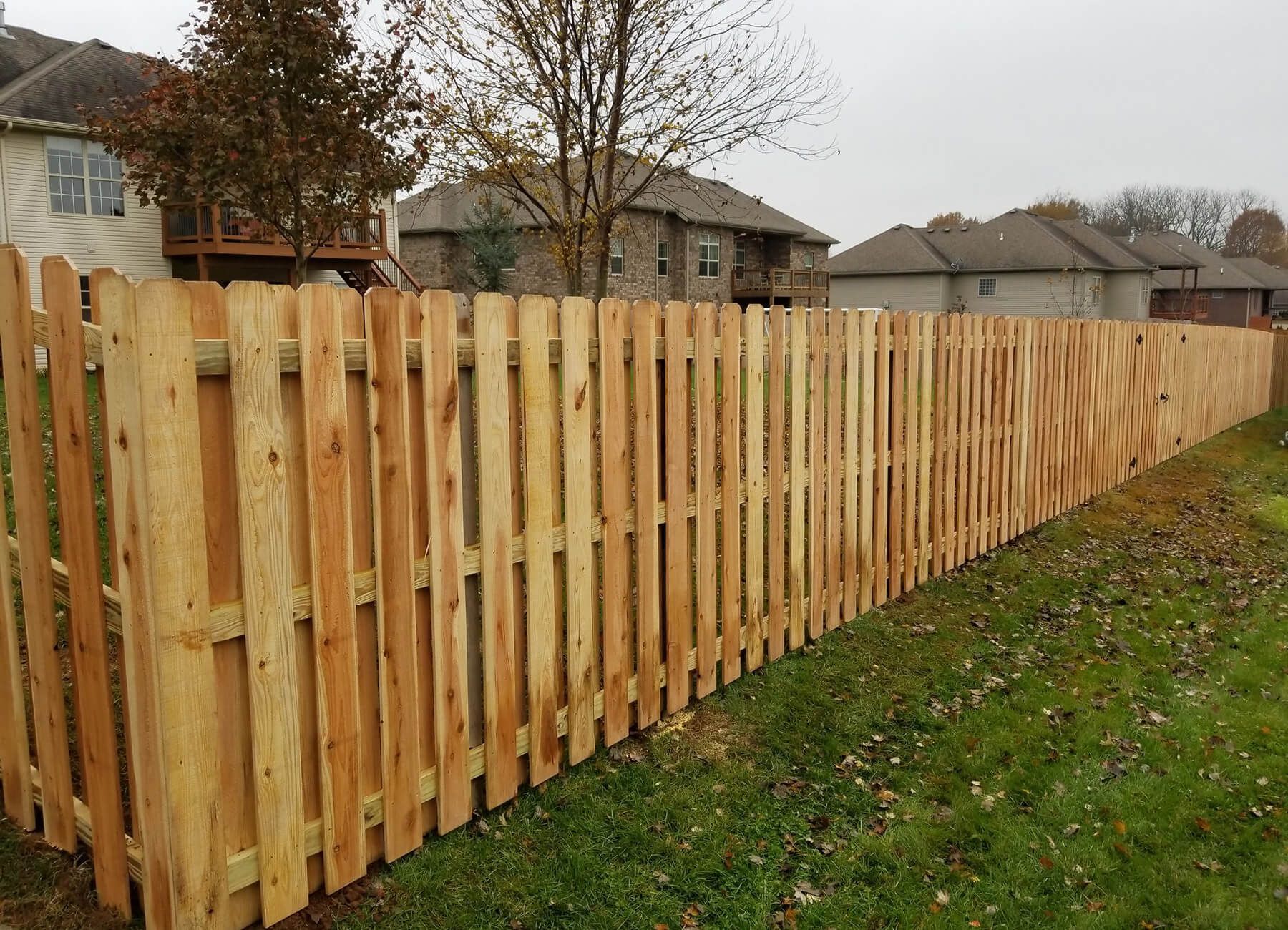 A wooden fence is sitting in the middle of a lush green field.