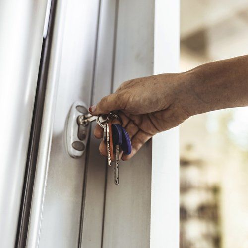 Woman Opening The Front Door — Saint Paul, MN — Kat – Key’s Lock & Safe Woman Opening The Front Door — Saint Paul, MN — Kat – Key’s Lock & Safe