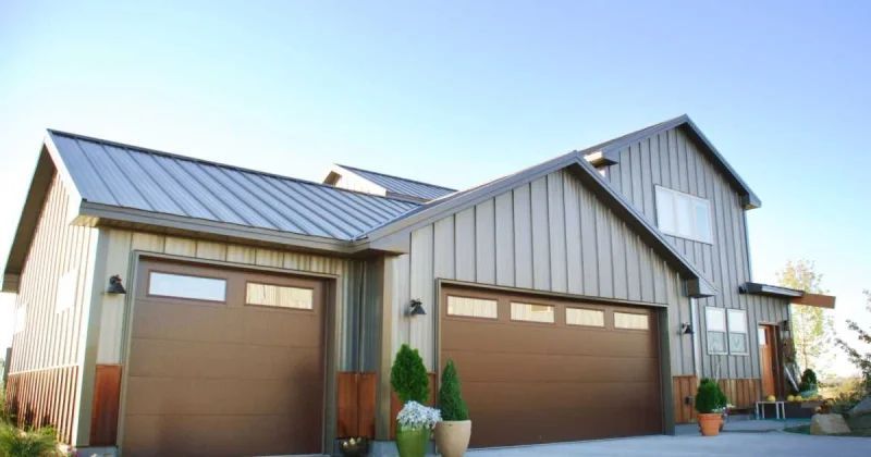 Two-car garage with brown doors and gray metal roof on a modern house exterior