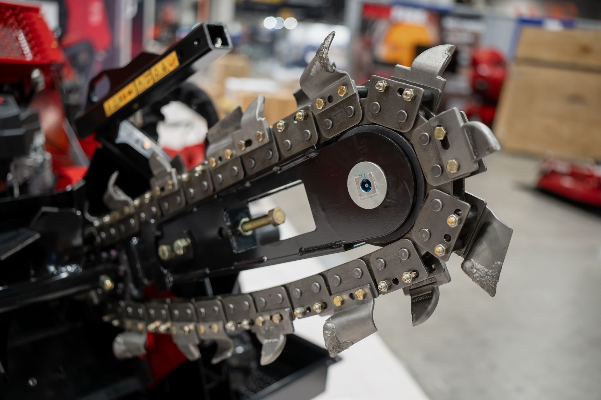 Close-up of industrial trenching machine chain with sharp cutting teeth.