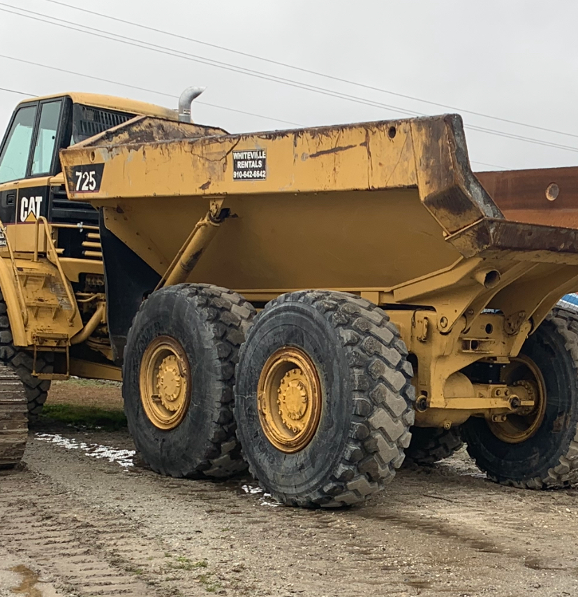Yellow Caterpillar 725 articulated dump truck, outdoors, construction site.
