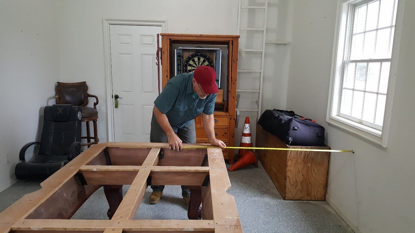 pool table measuring man in red cap