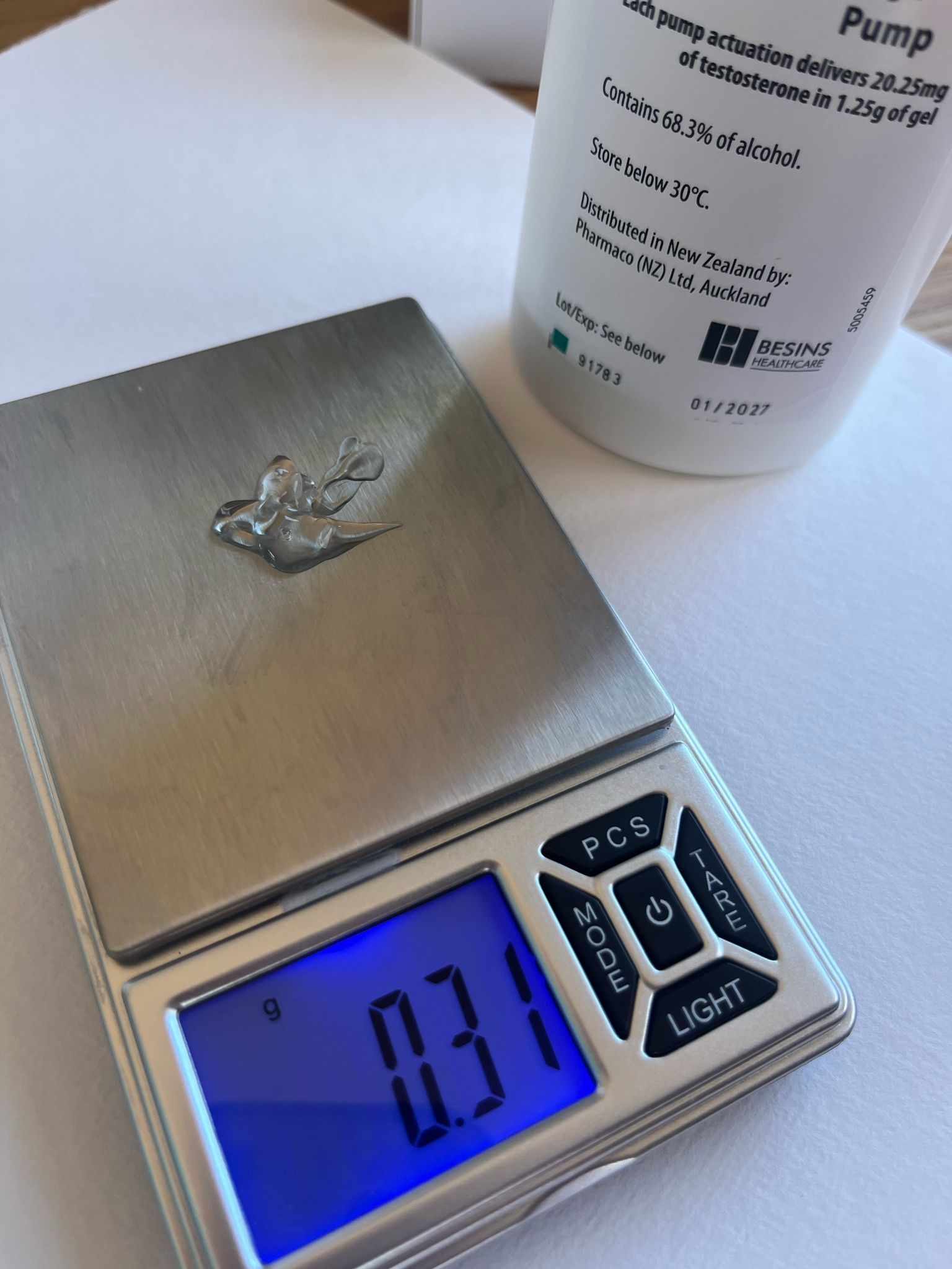 A small silver scale displays "0.31 g". A medication pump label is in the background.
