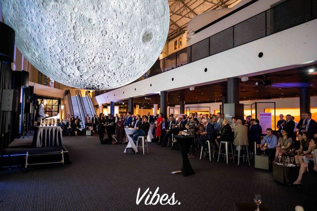 Vibes corporate awards event with a microphone, staged presentation and blue accent lighting.