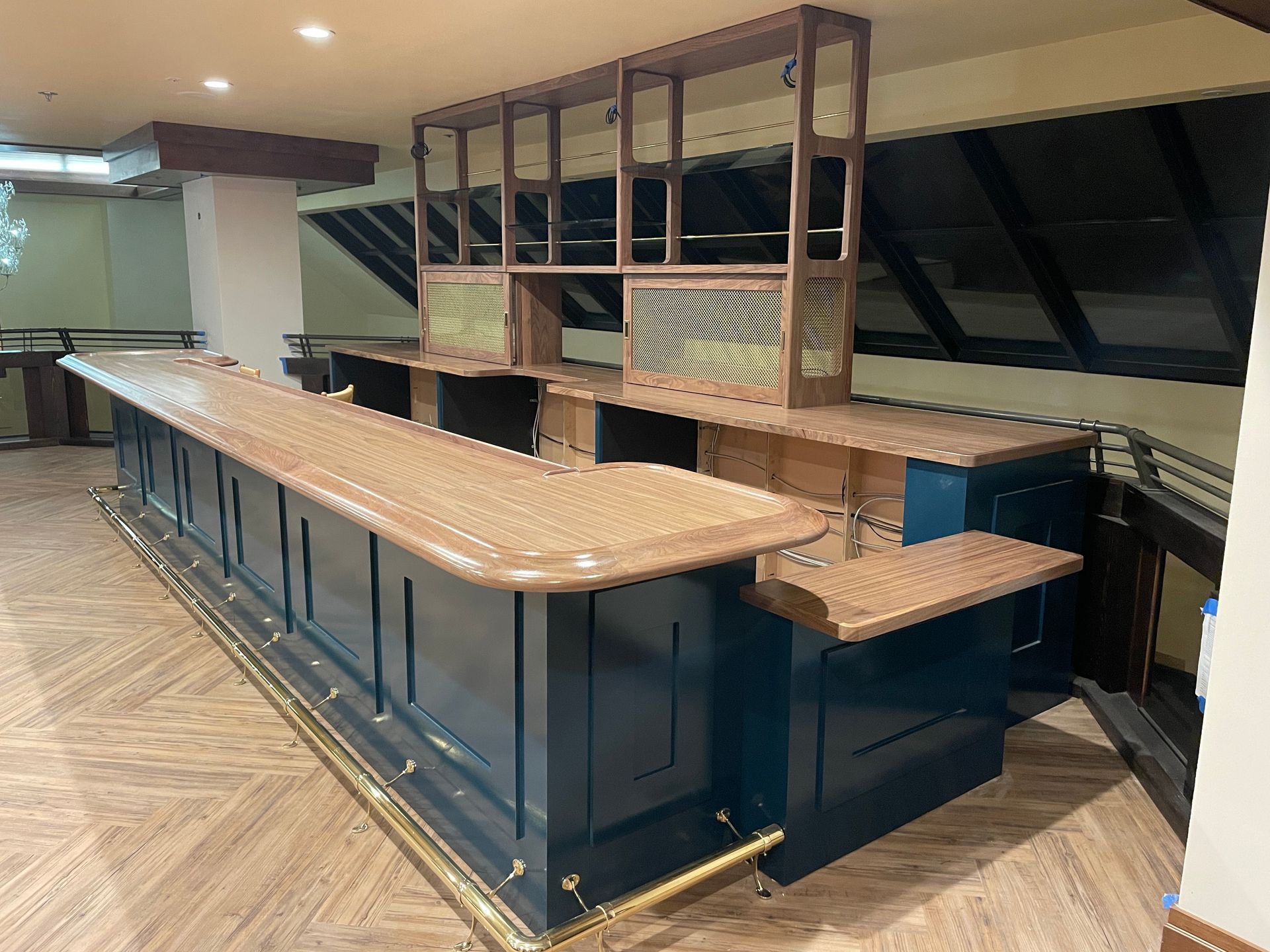 Empty bar counter with wooden stools and shelves in a modern lounge area