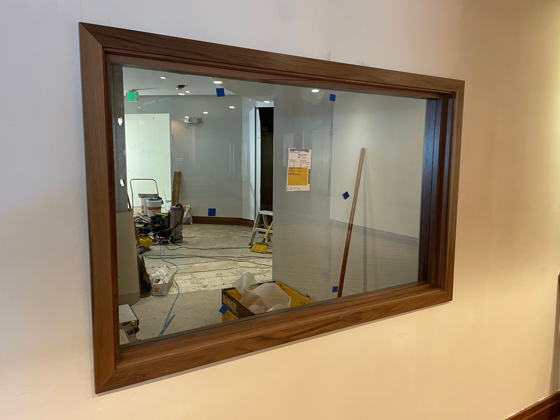 Framed interior window showing a room under renovation with tools and construction materials