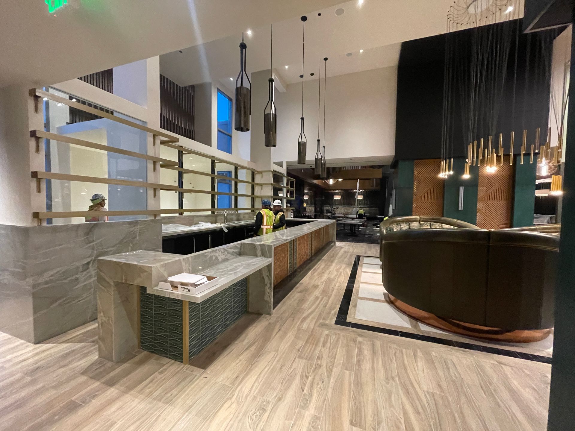 Modern hotel lobby with reception desk, warm pendant lights, seating area, and wood-accented decor