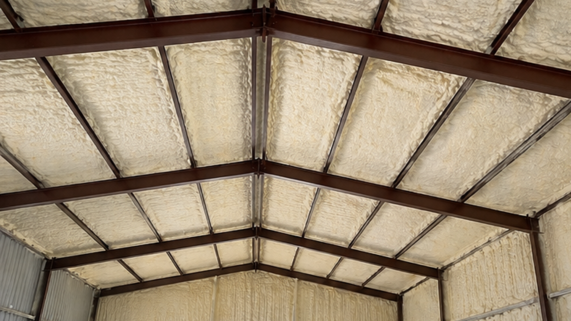 Technicians sealing gaps with expanding foam in attic structure