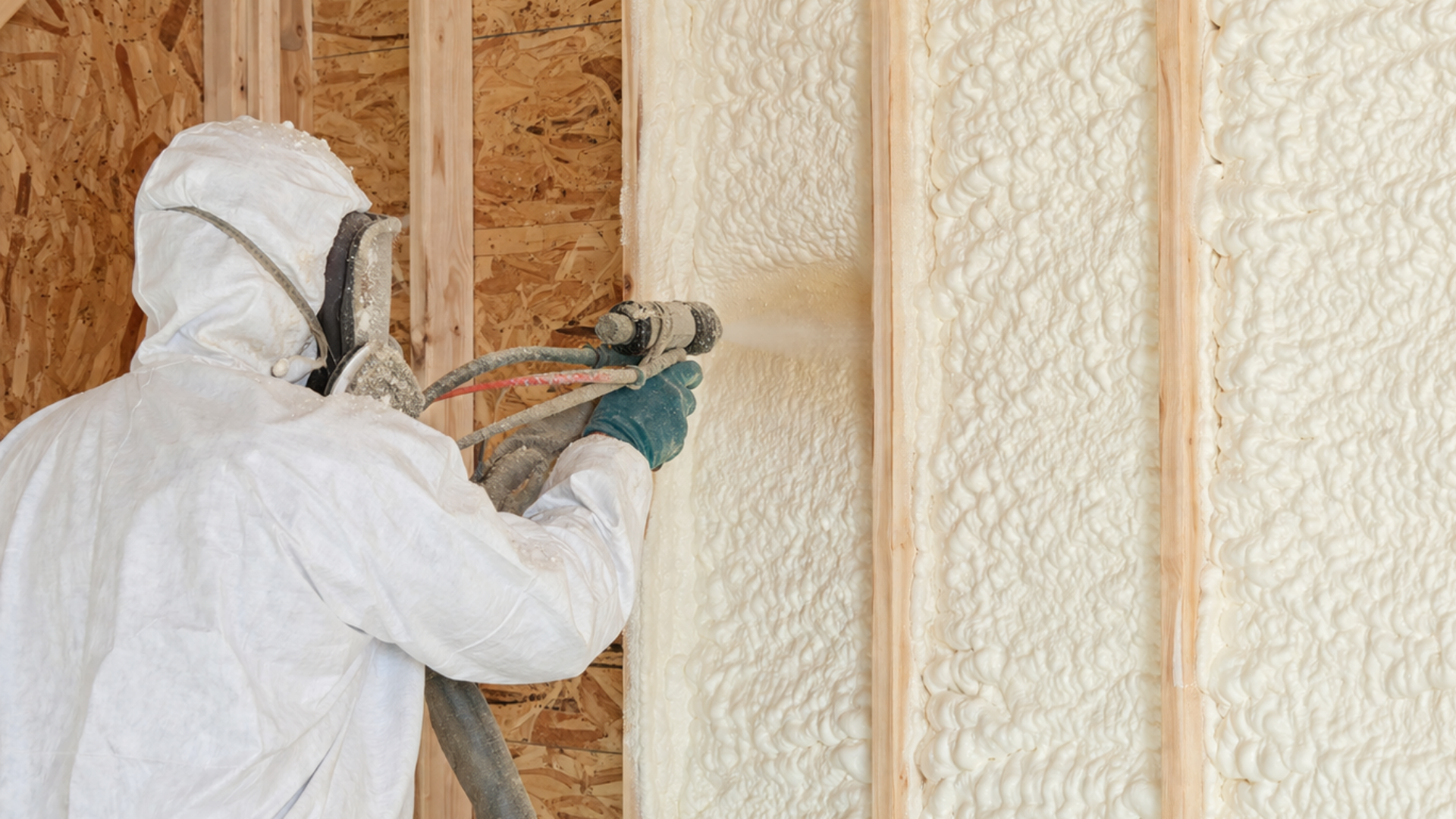 Professional technicians spraying foam insulation on steel building walls
