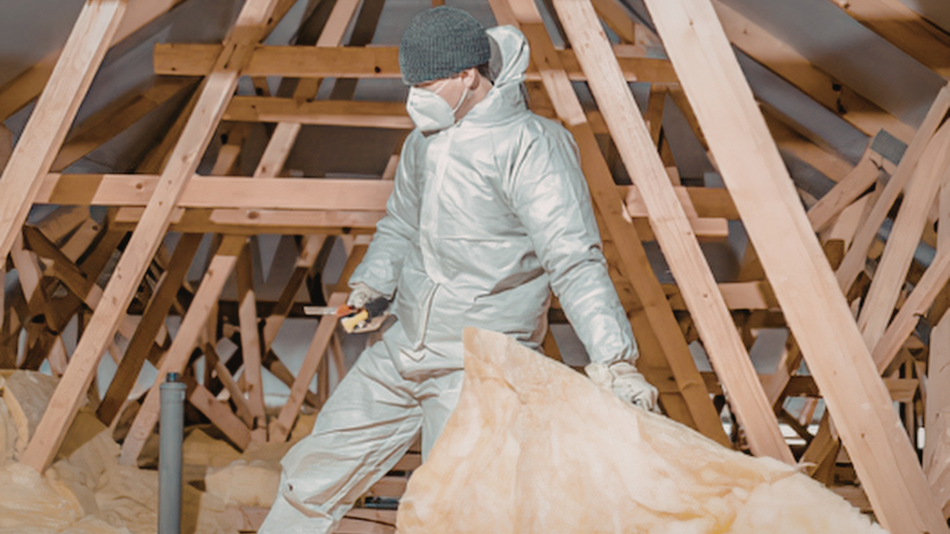 Technician installing closed cell spray foam in metal building structure