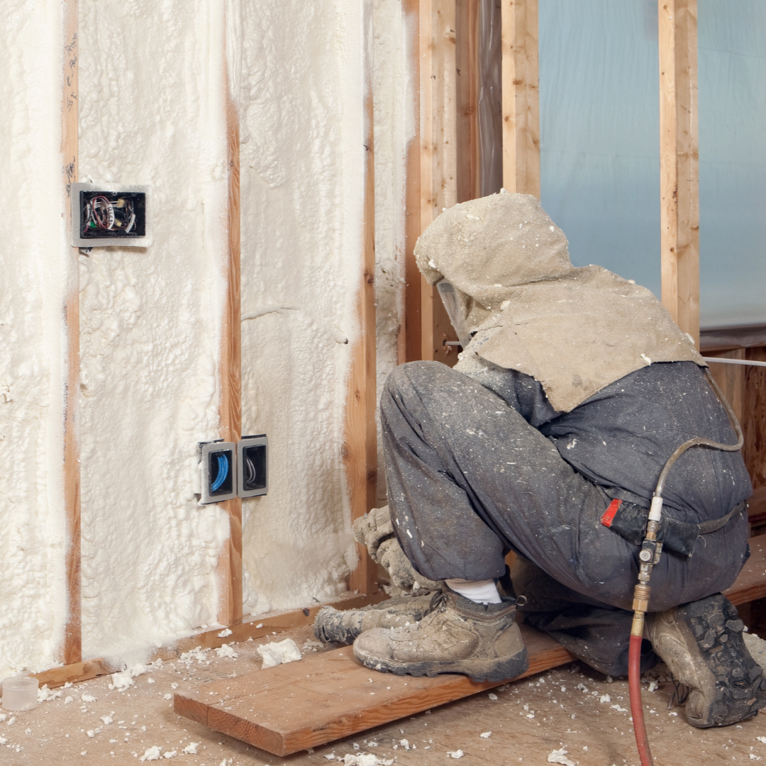 Workers applying insulation inside steel frame warehouse building