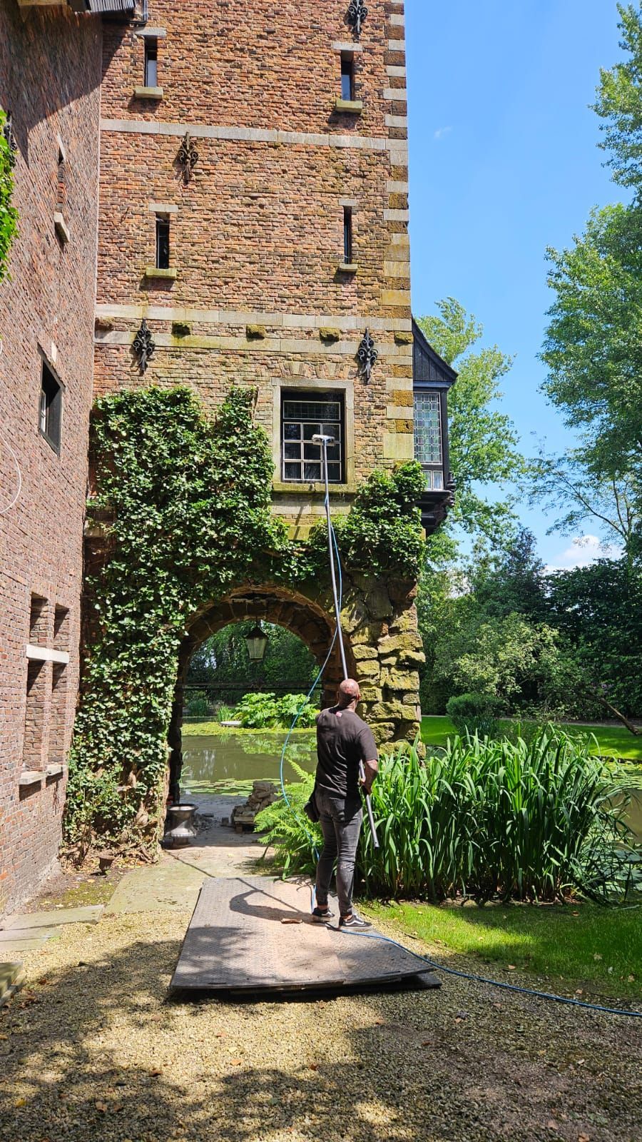 Een man staat voor een bakstenen gebouw.