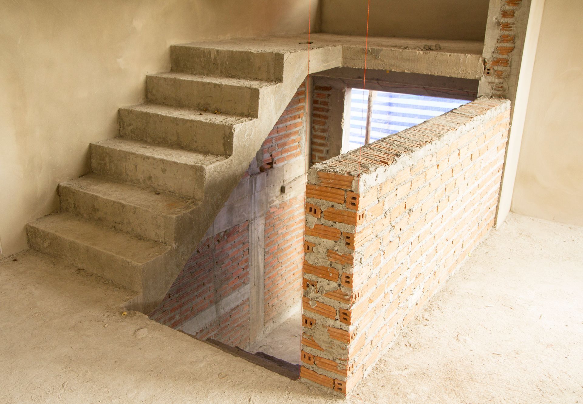Een betonnen trap in een kamer met een bakstenen muur.