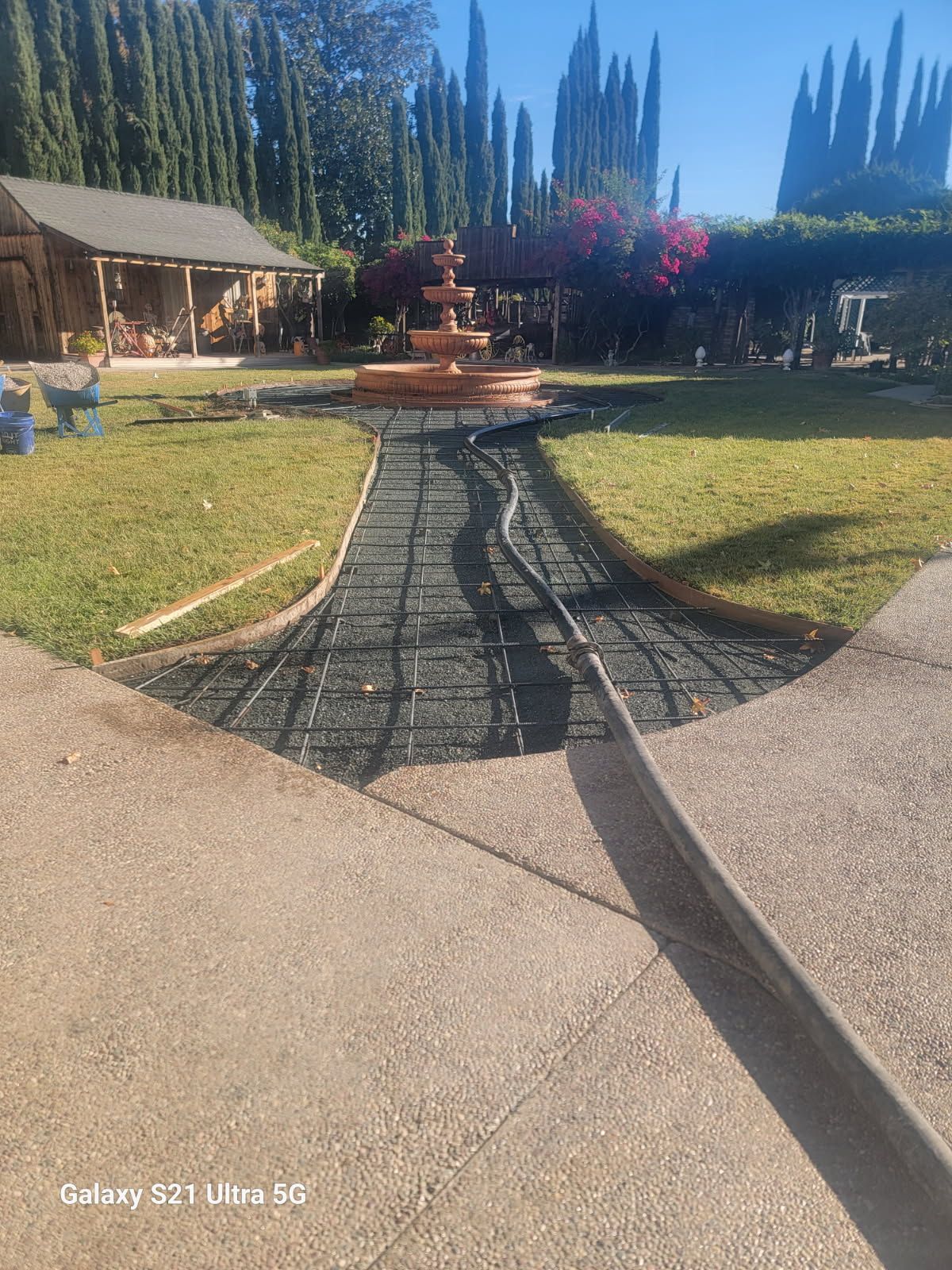 A concrete walkway is being built in front of a house