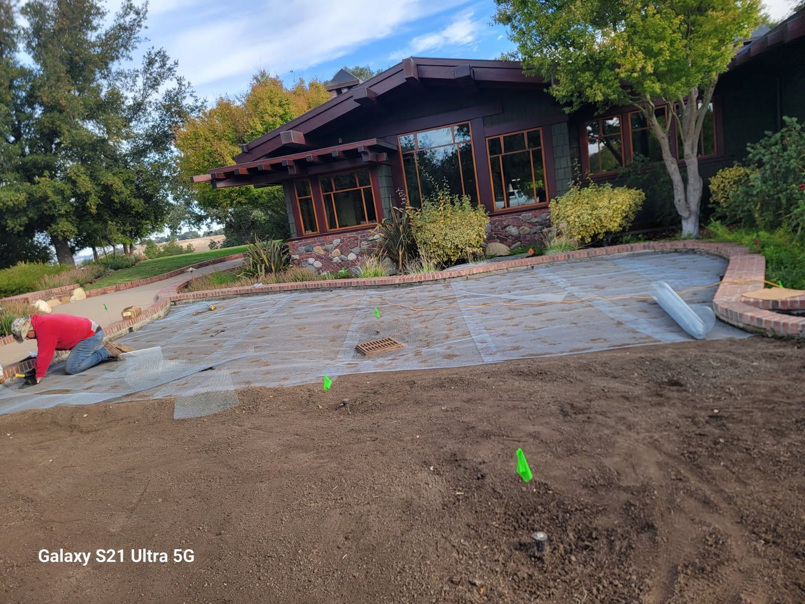 A man is working on a lawn in front of a house