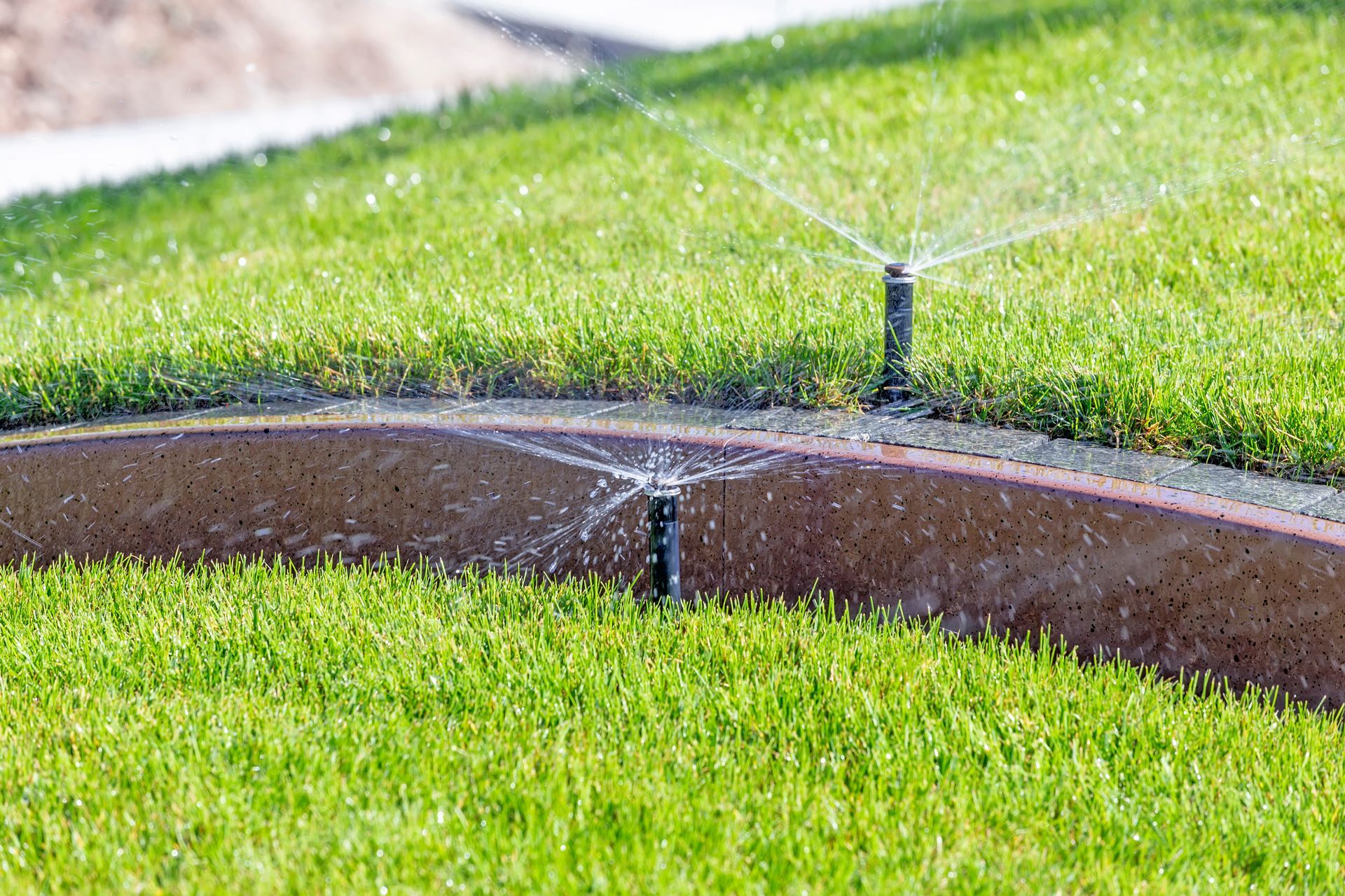 Two Sprinklers Are Spraying Water on a Lush Green Lawn