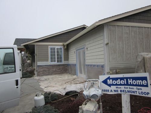 A white van is parked in front of a model home